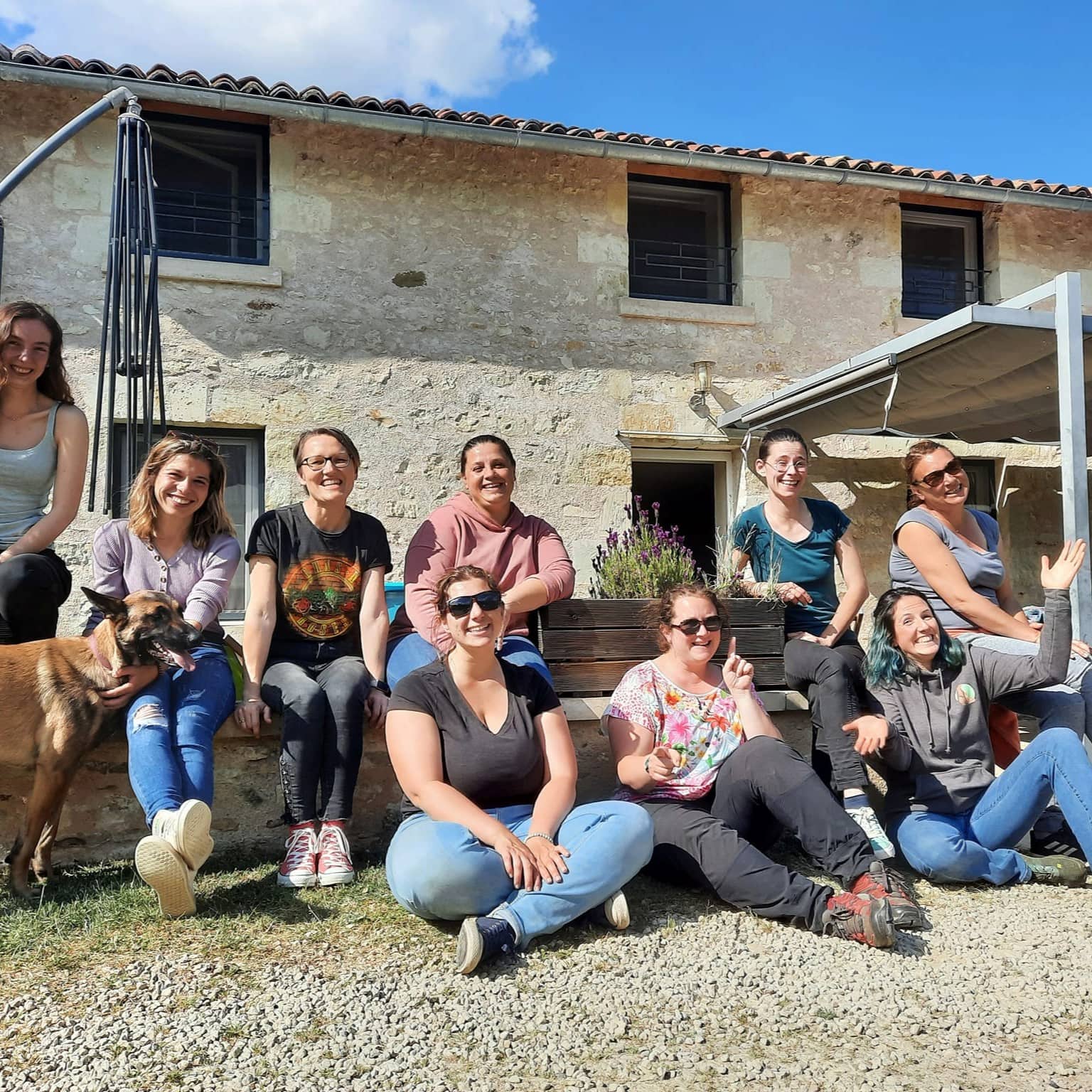 Groupe d'élèves d'un des stages de Céline. Elles sont assises au soleil et sourient à la caméra