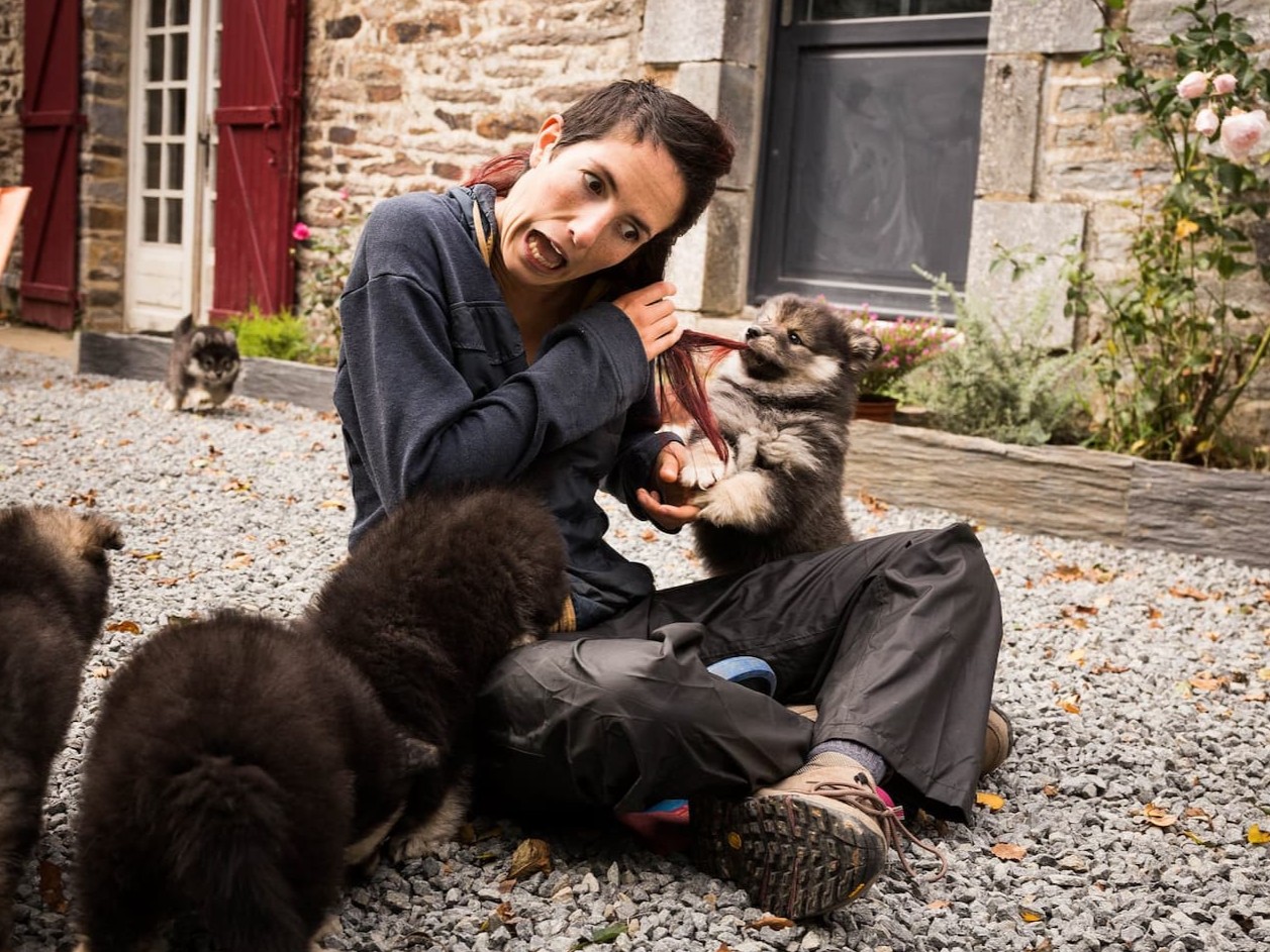 Céline se faisant tirer les cheveux par un chiot et faisant une grimace drôle