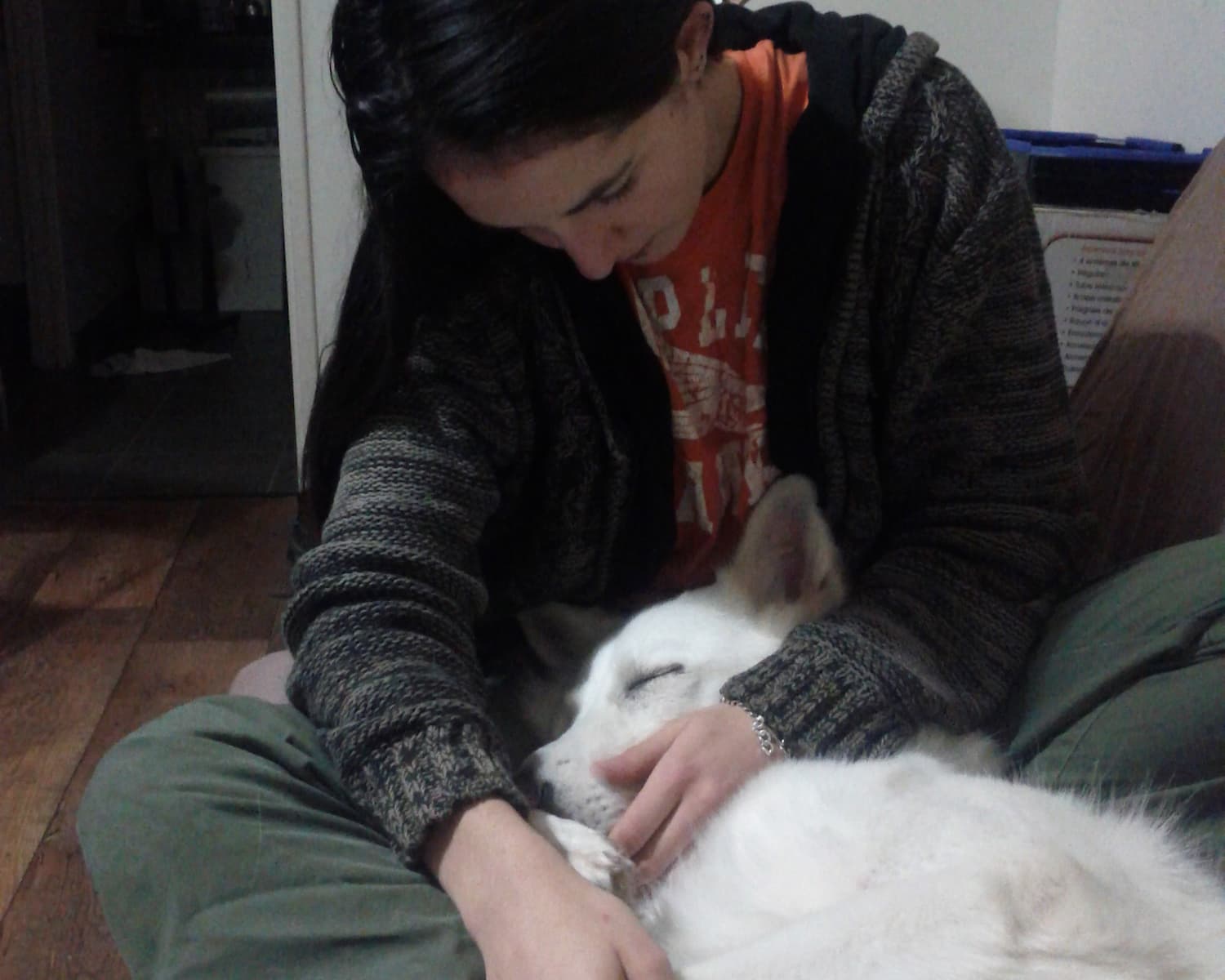 Céline assise sur un canapé, Laska couchée sur ses cuisses et caressée tendrement