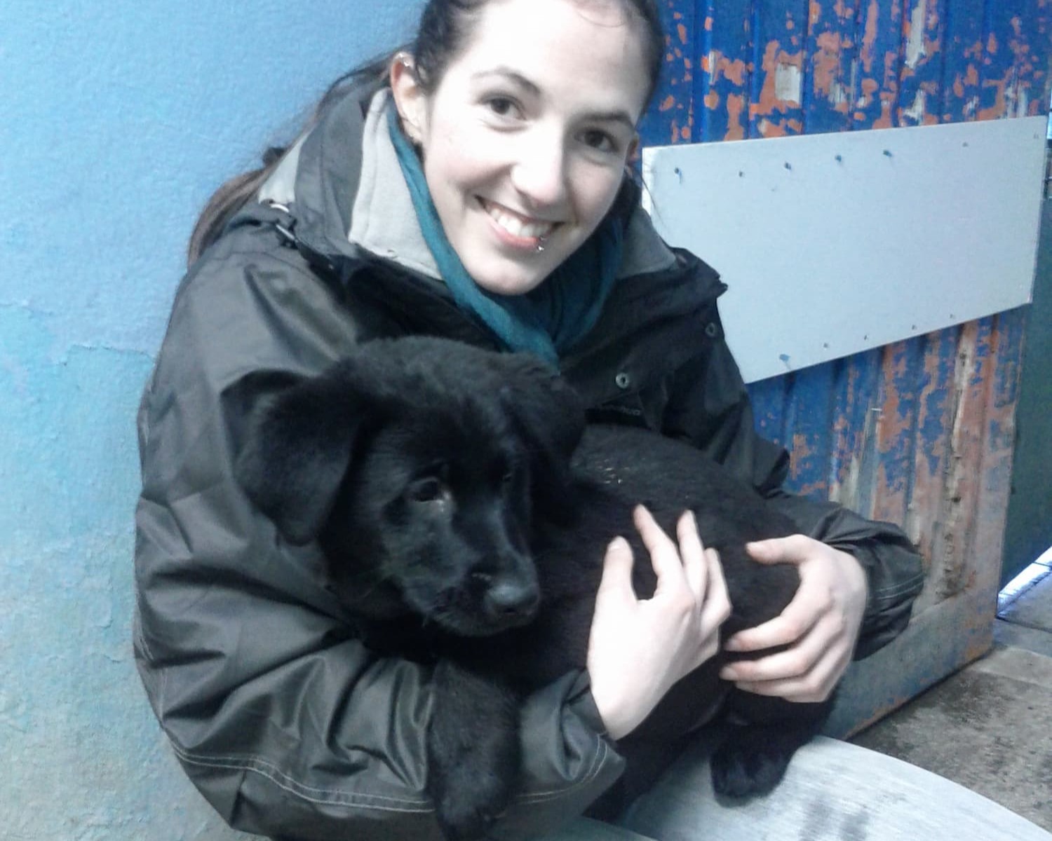Céline au refuge, tenant Vulcain dans ses bras et souriant d'un large sourire