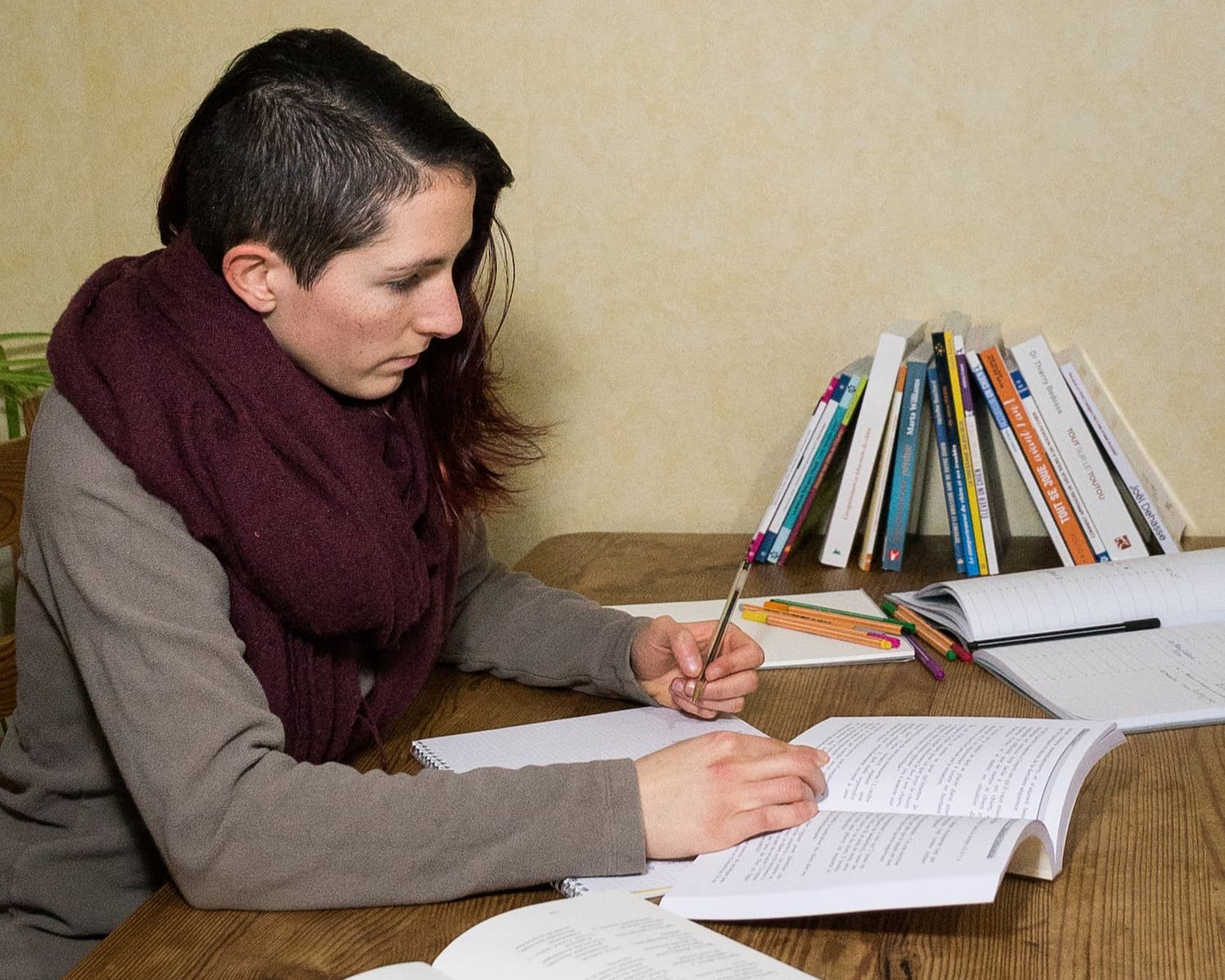 Portrait de Céline en train de prendre des notes en lisant un livre